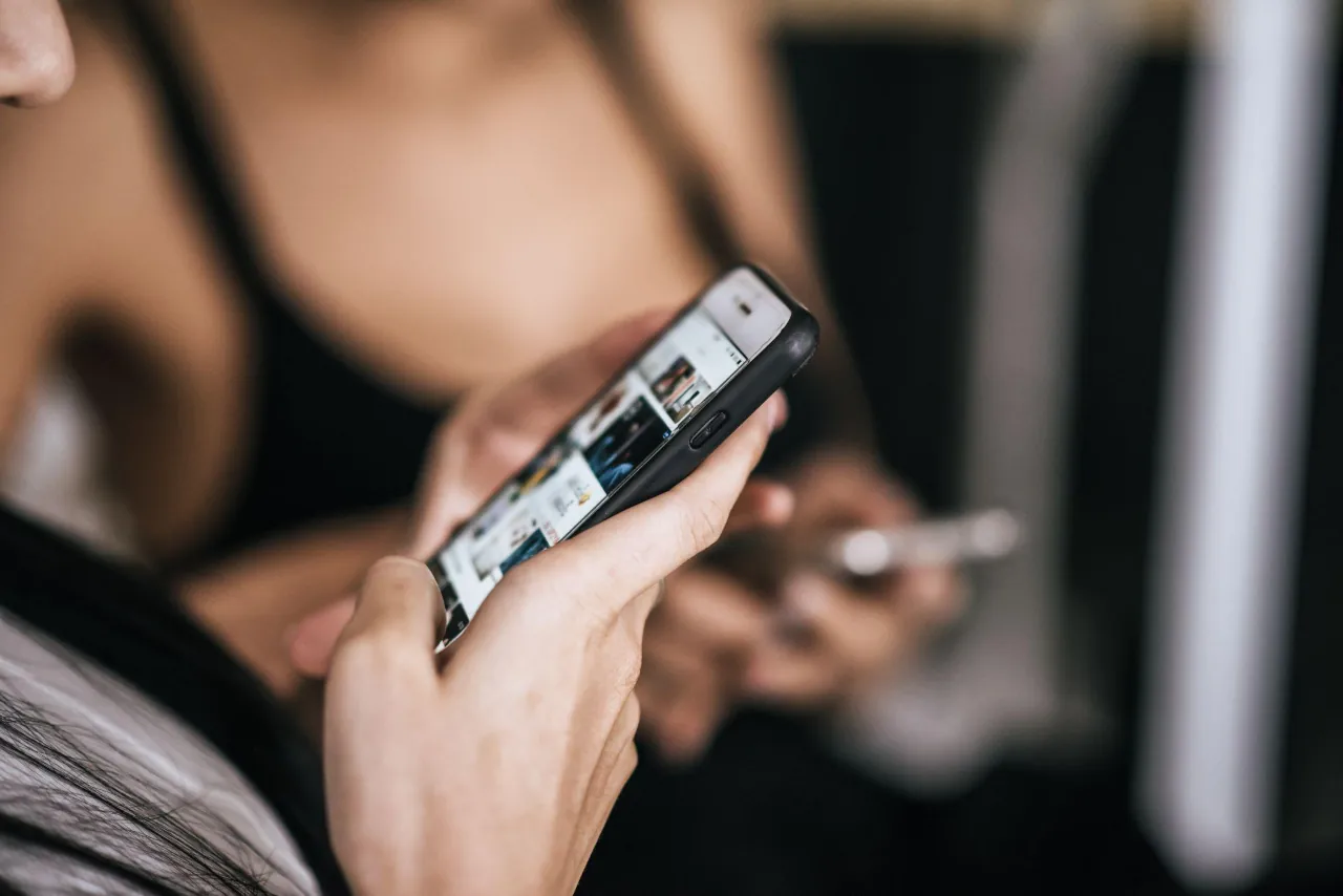 Utilizadora a navegar em redes sociais num smartphone, a ilustrar o suporte do emulador Android do Multilogin.