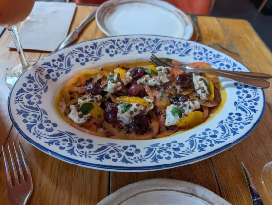 Sophia Natural Italian - Carpaccio de tomate de cora&ccedil;&atilde;o de boi, burrata, laranja, uvas, vinagre bals&acirc;mico, lentilhas e manjeric&atilde;o